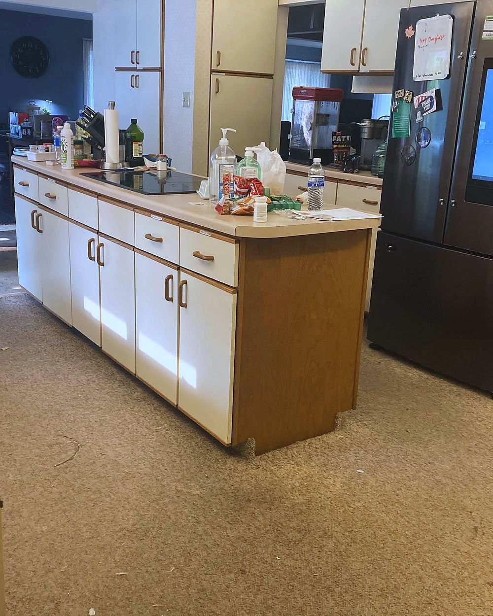 Kitchen before — worn carpet running right up to the cabinets